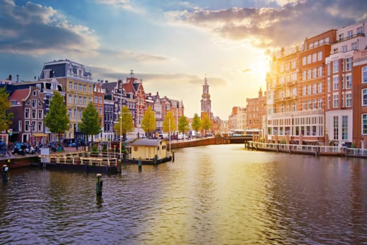 Amsterdam canal view with historic buildings and waterfront at sunset
