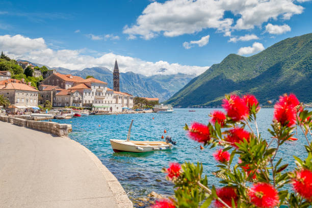 10 Best Places To Visit In Europe In Summer Bay of Kotor with red flowers and mountains, one of the stunning Places To Visit In Europe In Summer - Image by iStockphoto.com