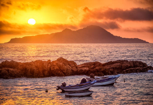 10 Best Places To Visit In Europe In Summer Small boats on the water at sunset in the Cíes Islands, a hidden paradise for a summer in Spain - Image by iStockphoto.com